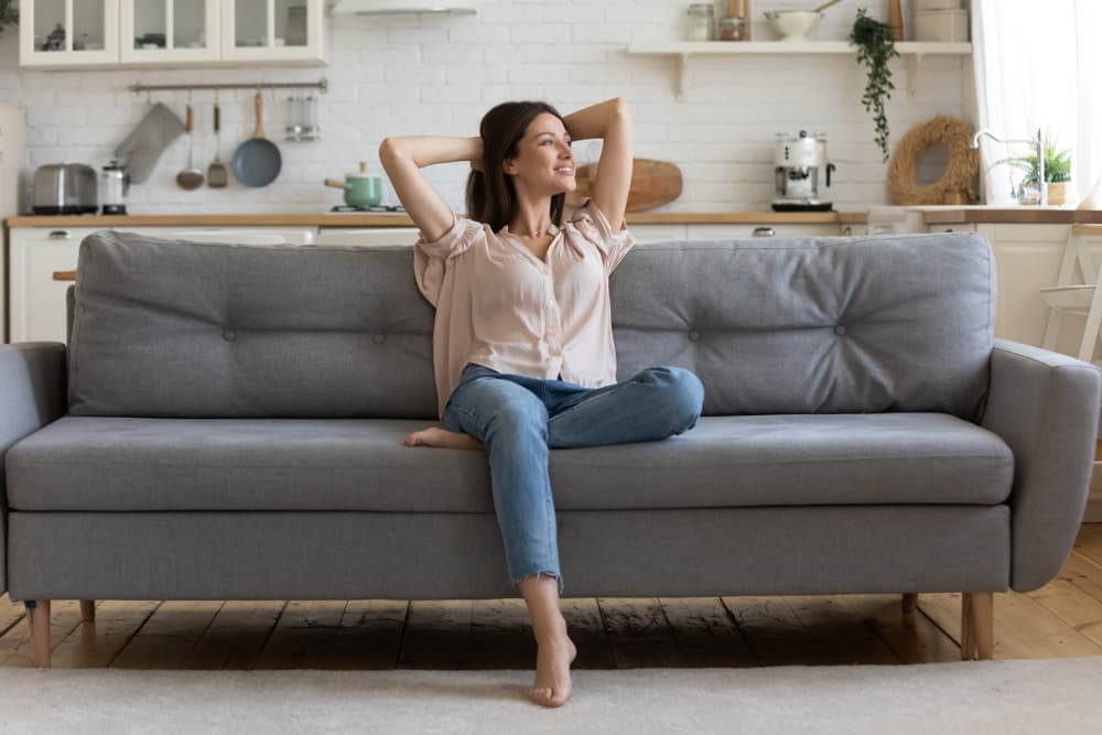 Cliente relaxando em sofá recém-higienizado